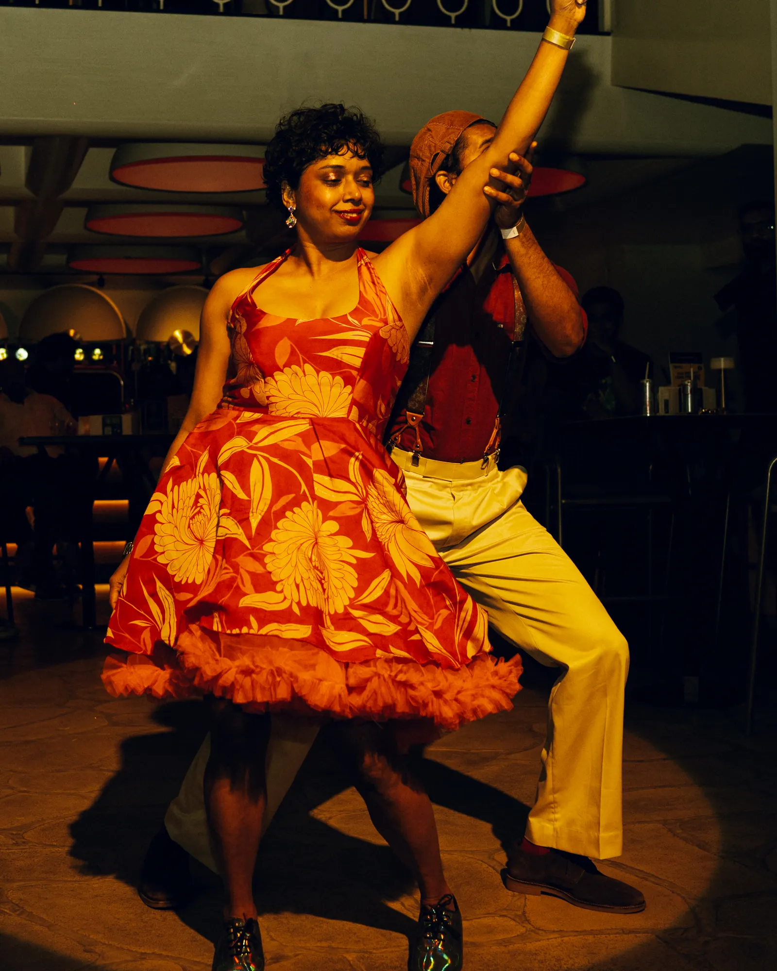 Divya of Ownd mid-move in a bright dress, spotlit on the venue floor