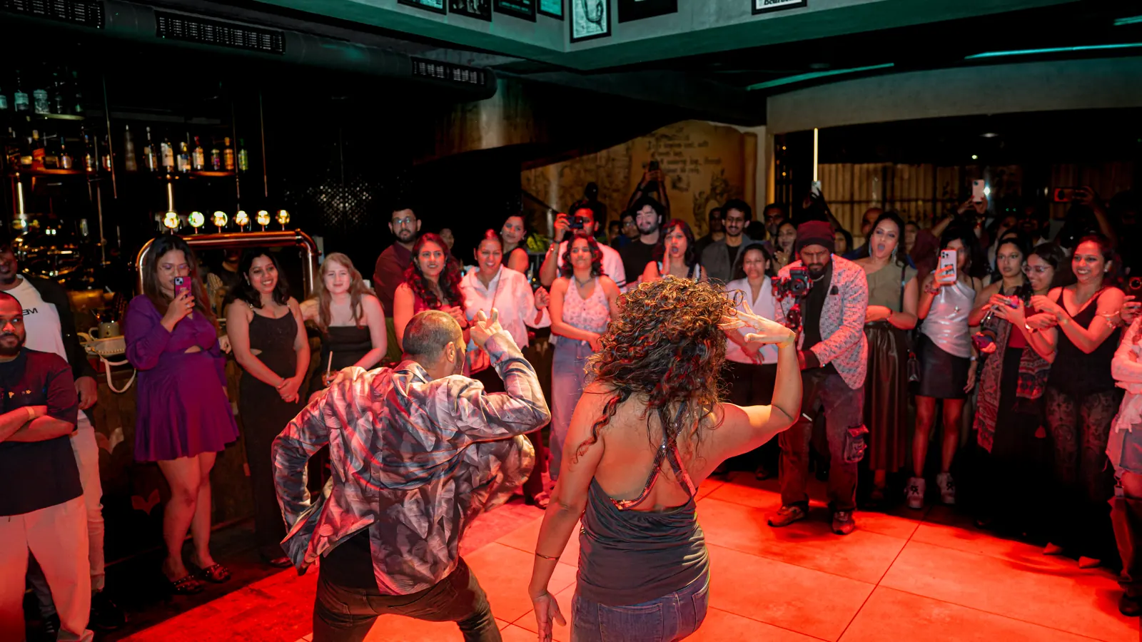 A dip in the middle of a red-lit circle of people