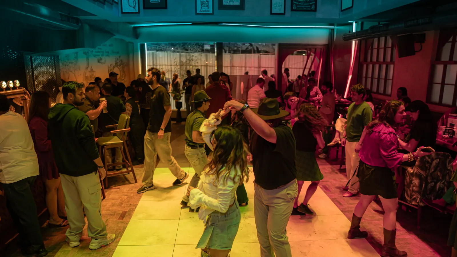 The dance floor packed, lit teal and yellow