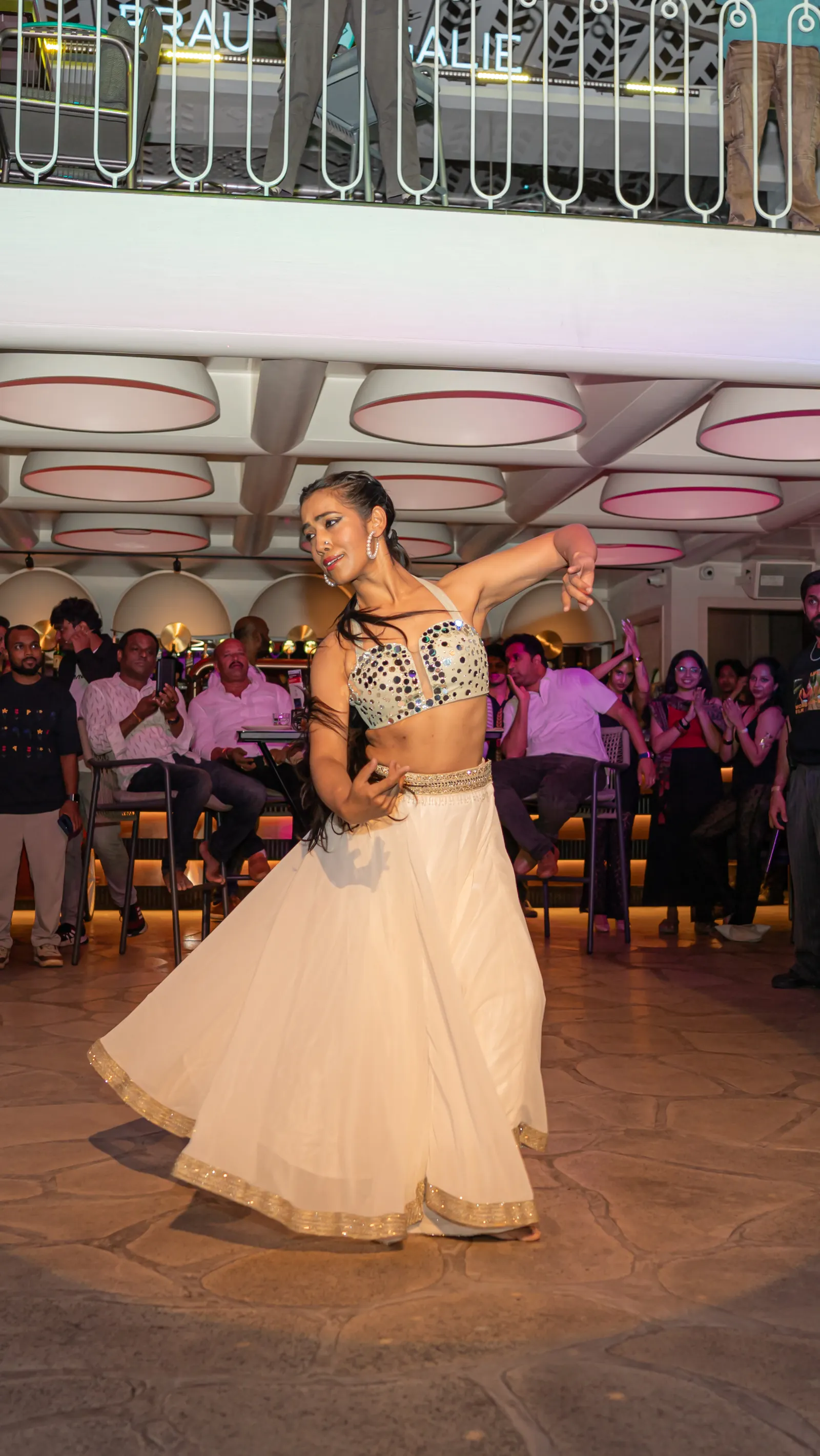 A dancer's white skirt fanned mid-spin, the crowd behind